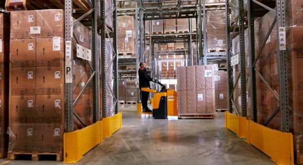 An employee making sure the goods are being placed in the right shelves in the storage
