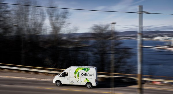 Electrical ColliCare van driving through Norwegian scenery for express delivery