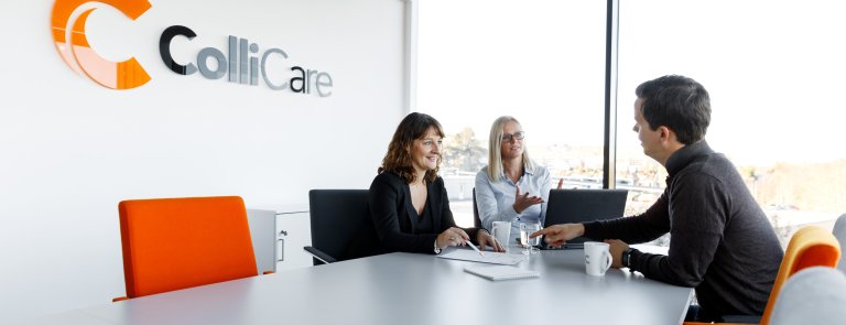 Three ColliCare-employees conversating about solutions and logistics at a ColliCare office.