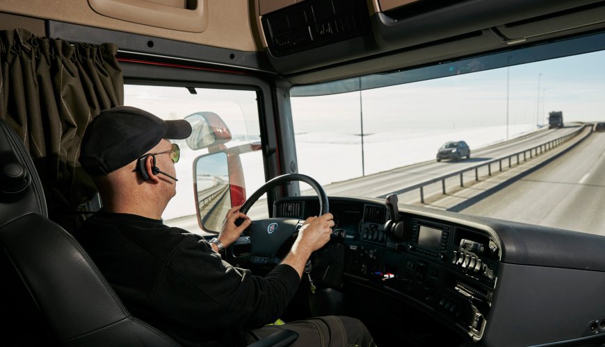 Man driving a crane-trailer for ColliCare Logistics during the cold Norwegian winter.