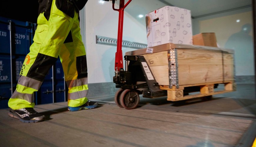 ColliCare-employee packing goods in truck, preparing it for delivery during night time.