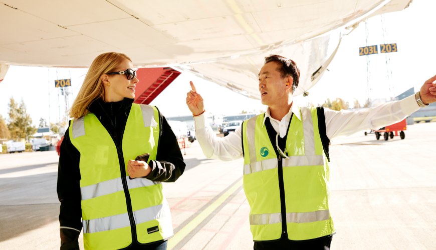 ColliCare-ansatt og pilot diskuterer logistikk og luftfart på en flyplass.