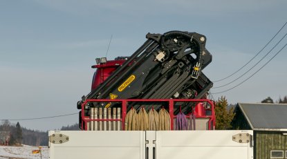 ColliCare kranbil kjører gjennom et nabolag for å komme frem til kunden for av- og pålasting av varer. 