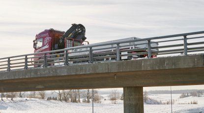 ColliCare kranbil kjører over en bro om vinteren