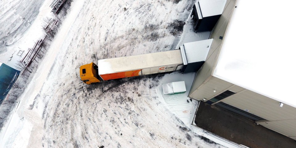 En merket ColliCare lastebil sett ovenfra parkert til lageret for å laste og losse varer
