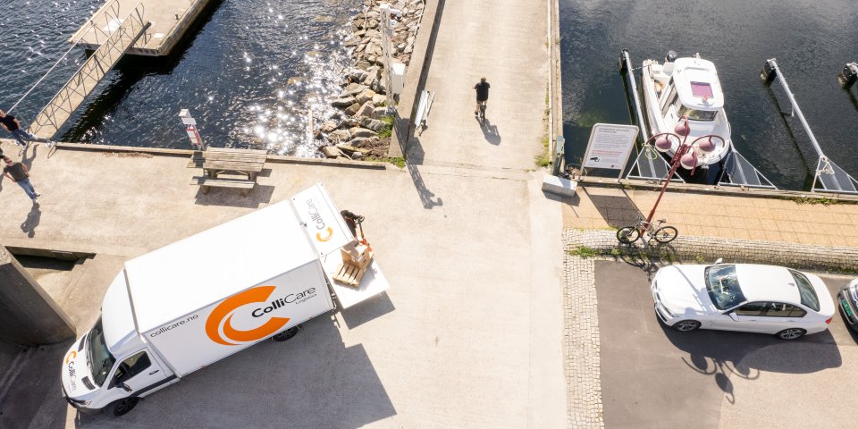 ColliCare lastebil parkert ved båthavn for å ta imot varer