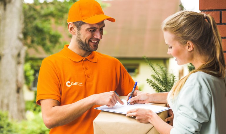 Glad mann i oransje uniform og en jente som signerer kvittering for levert pakke